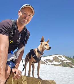Zero Dean and Koti on a rock surrounded by snow.